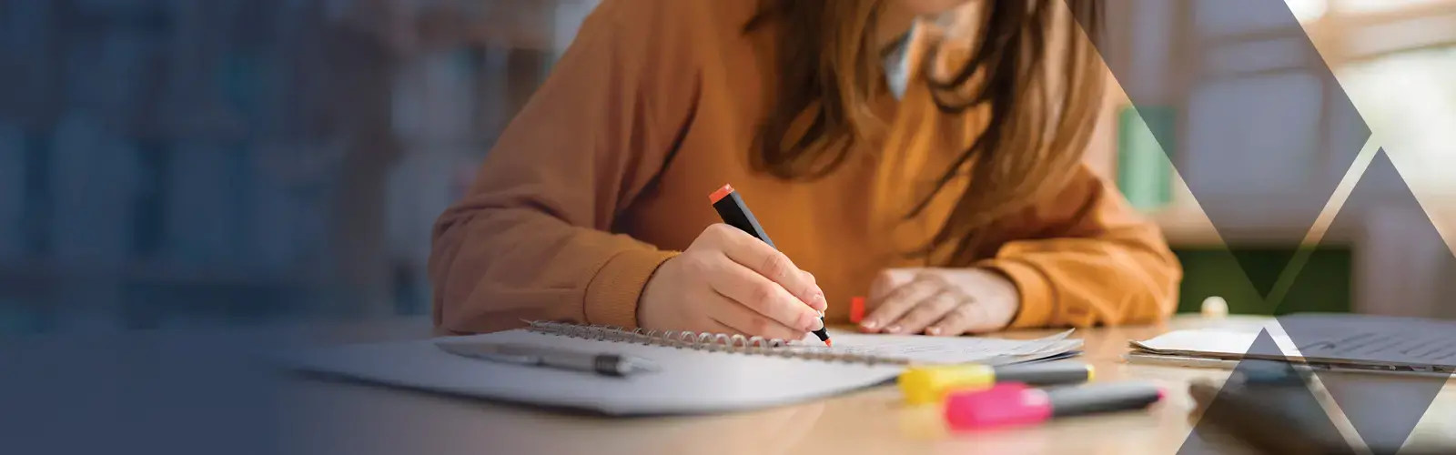 Woman highlighting text on document with highlighters on a desk 