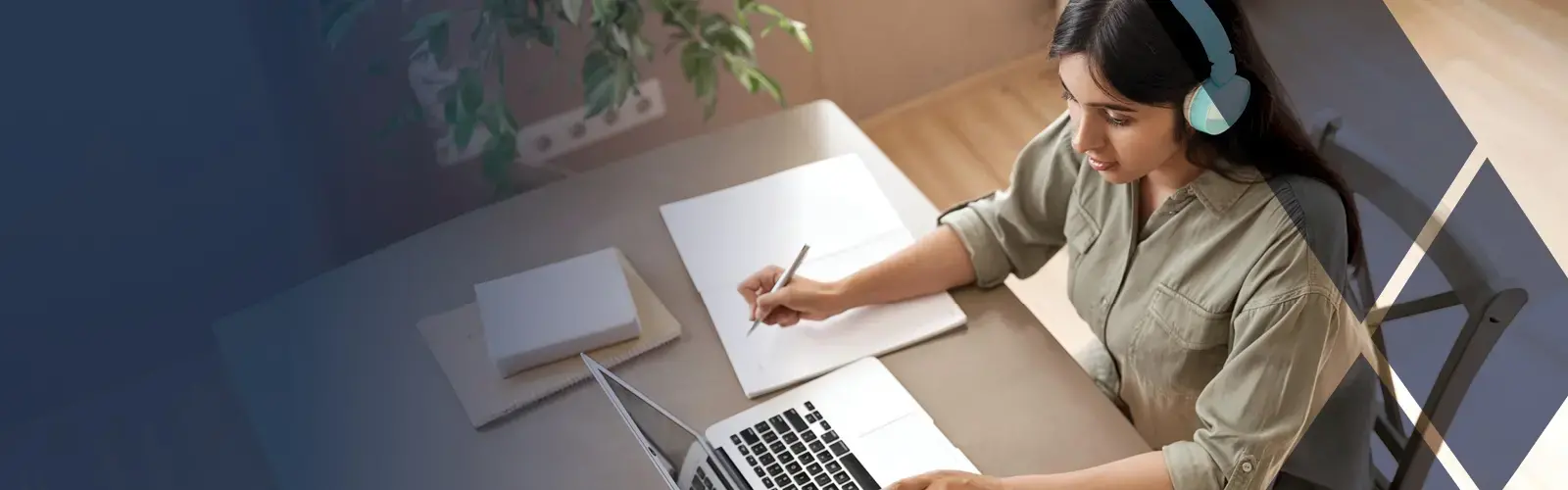 Female student wearing headphones, looking at laptop computer and learning online.